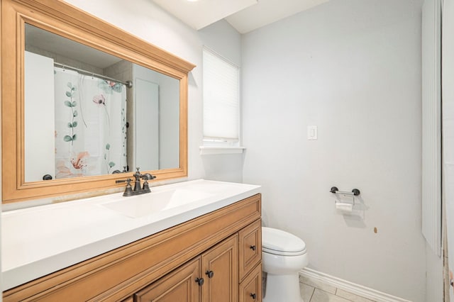 bathroom with tile patterned flooring, vanity, toilet, and baseboards