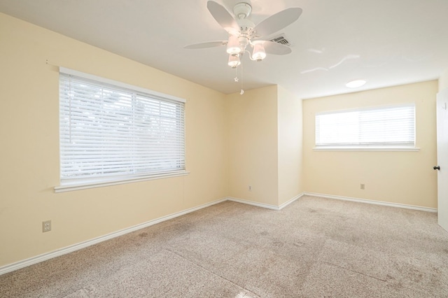 unfurnished room with a ceiling fan, carpet flooring, visible vents, and baseboards