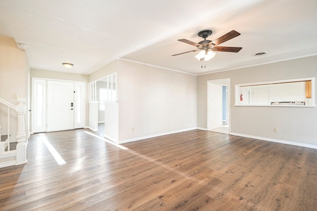 unfurnished living room featuring baseboards, crown molding, visible vents, and wood finished floors