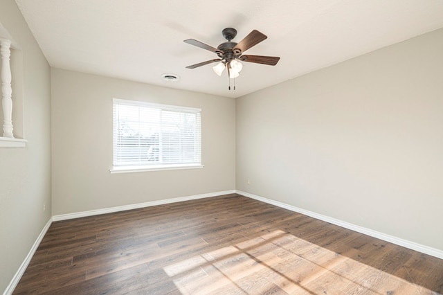 spare room featuring visible vents, ceiling fan, baseboards, and wood finished floors