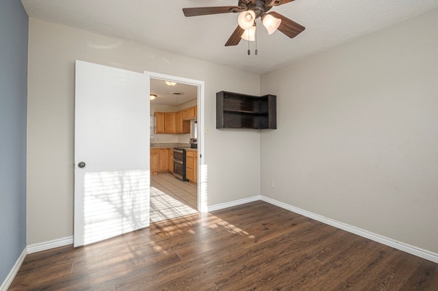 unfurnished room featuring a ceiling fan, light wood-type flooring, and baseboards