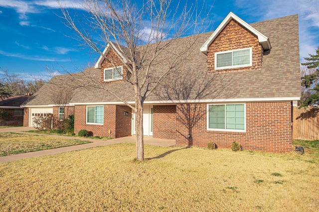 view of front facade with a front yard, brick siding, an attached garage, and roof with shingles