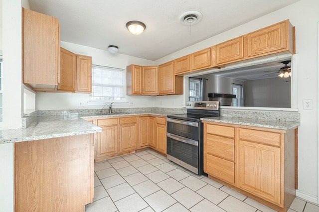 kitchen featuring range with two ovens, light brown cabinets, and a sink