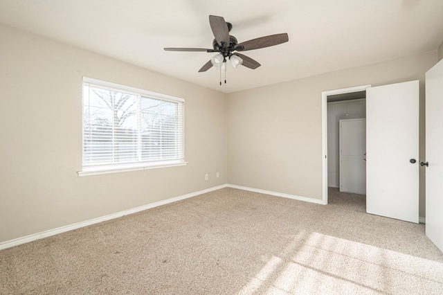 interior space with carpet floors, a ceiling fan, and baseboards