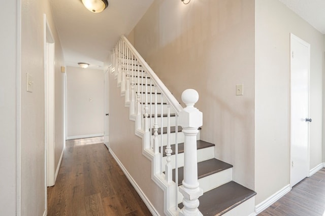 stairway featuring baseboards and wood finished floors