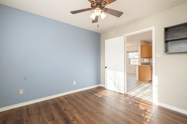 unfurnished room with light wood finished floors, ceiling fan, and baseboards