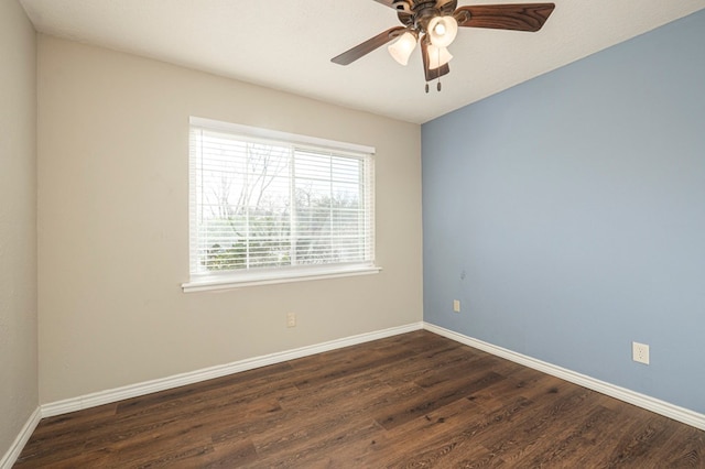 spare room featuring dark wood-style flooring, ceiling fan, and baseboards