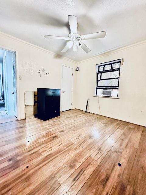 unfurnished living room with hardwood / wood-style floors, ceiling fan, and ornamental molding