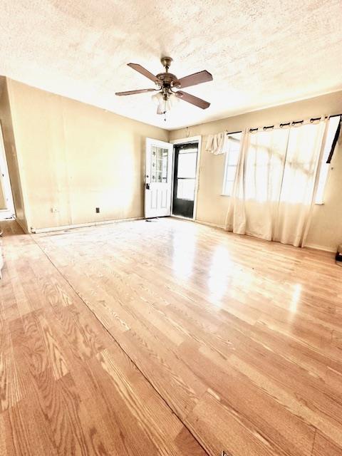 spare room featuring a textured ceiling, light hardwood / wood-style floors, and ceiling fan