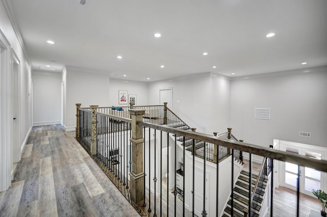 hall with ornamental molding and light hardwood / wood-style flooring