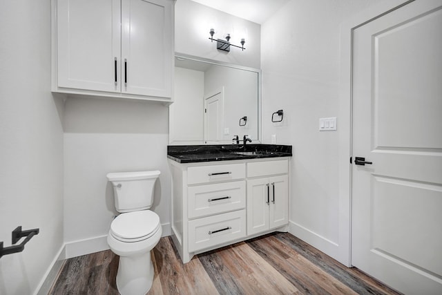 bathroom with hardwood / wood-style floors, vanity, and toilet