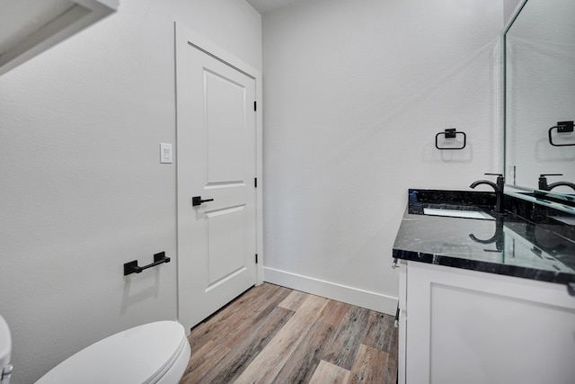 bathroom featuring vanity, wood-type flooring, and toilet