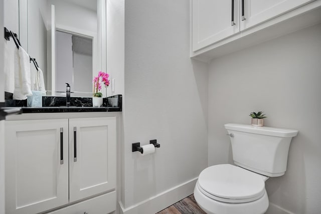 bathroom with wood-type flooring, vanity, and toilet