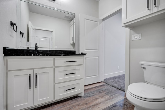 bathroom featuring vanity, toilet, and wood-type flooring