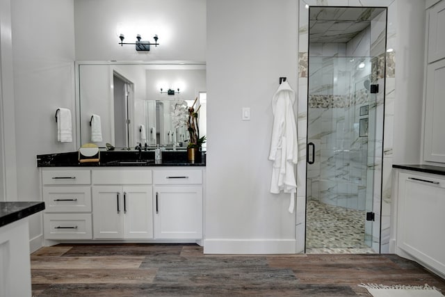 bathroom with hardwood / wood-style floors, vanity, and an enclosed shower