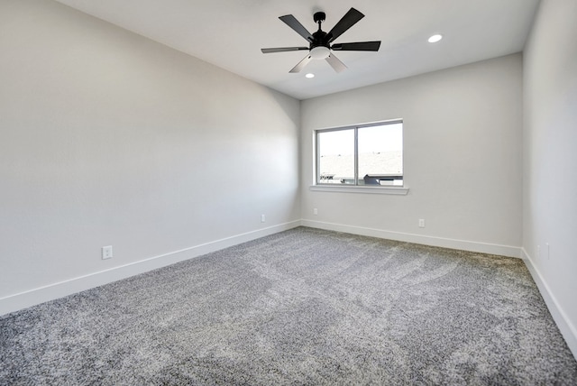 carpeted spare room featuring ceiling fan