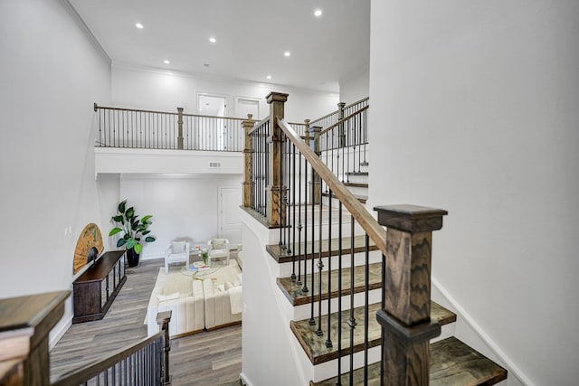 staircase with hardwood / wood-style flooring and ornamental molding