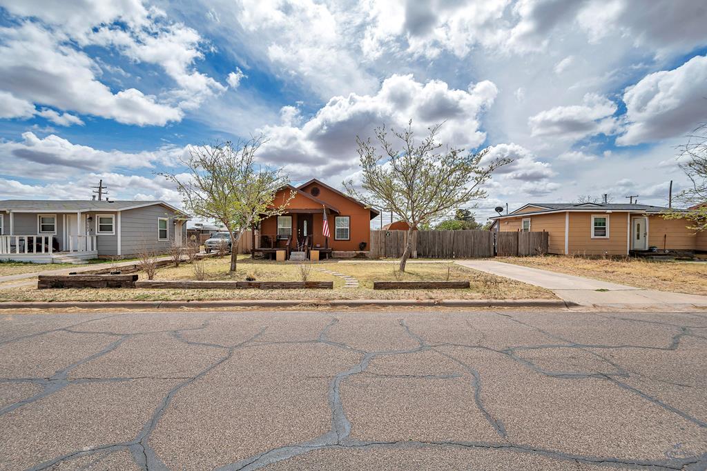 bungalow-style home featuring a porch, driveway, and fence