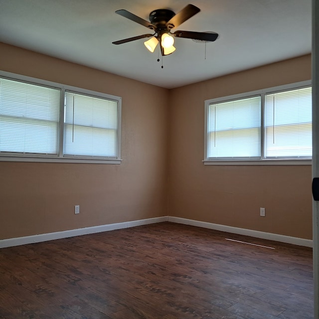 spare room featuring dark hardwood / wood-style flooring and a wealth of natural light