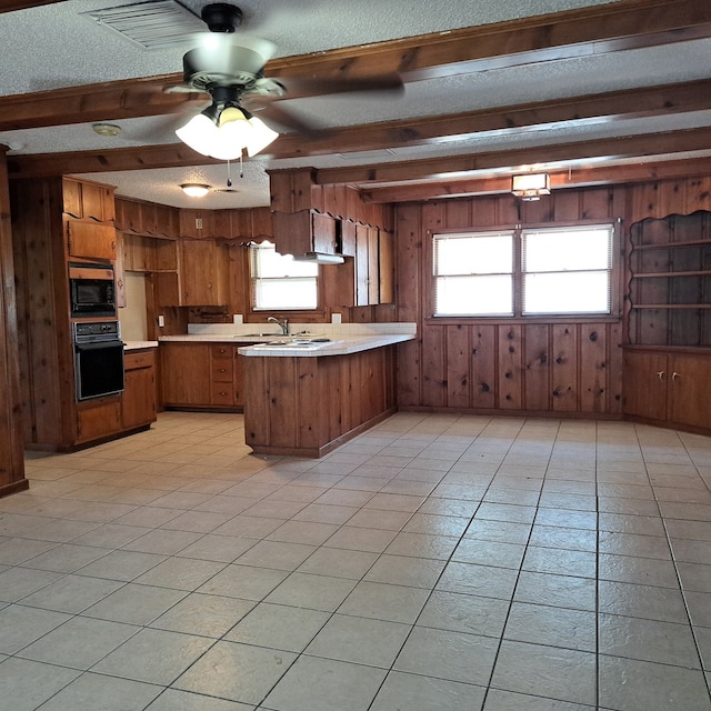 kitchen with kitchen peninsula, a textured ceiling, plenty of natural light, and black appliances