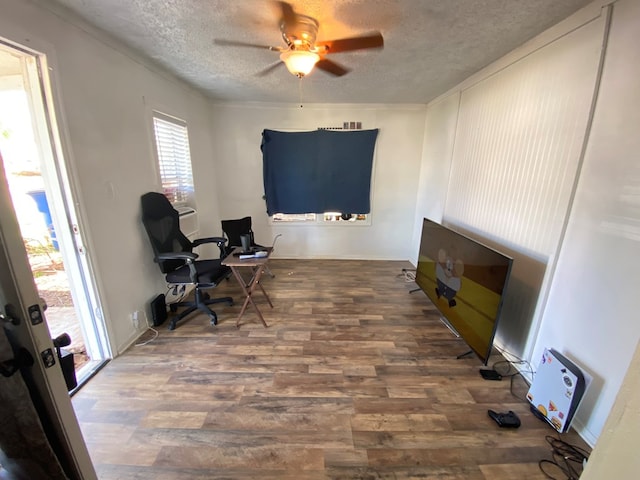 home office with ceiling fan, a textured ceiling, baseboards, and wood finished floors
