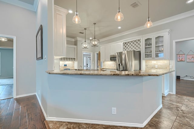 7005 Ridgeboro Ct, Midland, TX 79707 - kitchen featuring appliances with stainless steel finishes, crown molding, decorative backsplash, white cabinets, and light stone countertops