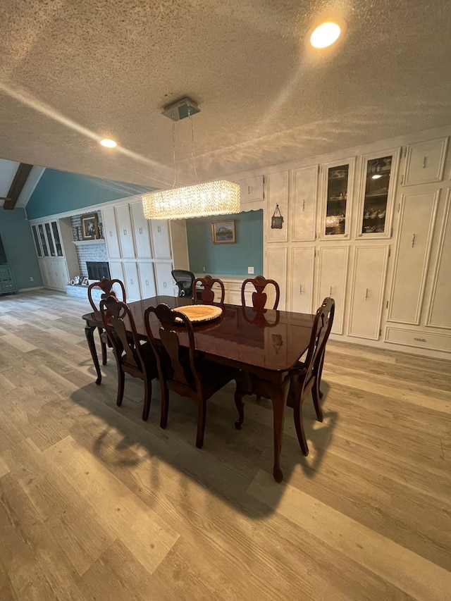 2804 33rd St, Snyder, TX 79549 - dining space featuring a textured ceiling, light wood-style floors, a fireplace, and recessed lighting