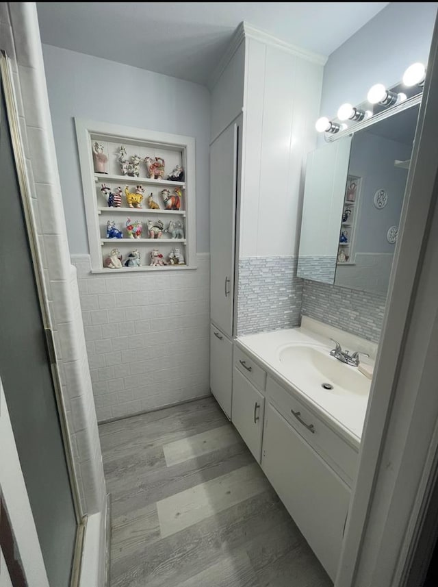 2804 33rd St, Snyder, TX 79549 - full bath with wood finished floors, vanity, a shower with curtain, tile walls, and wainscoting