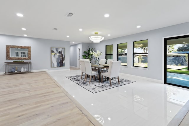 dining room featuring a notable chandelier, a healthy amount of sunlight, and light hardwood / wood-style floors