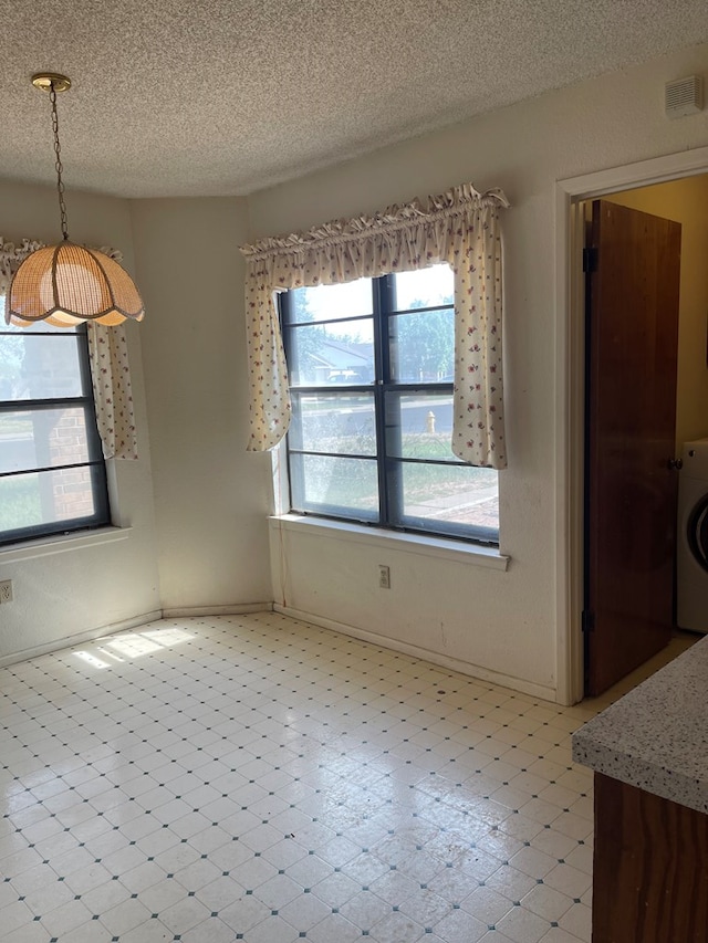 4400 Palmer Dr, Midland, TX 79705 - unfurnished dining area featuring a textured ceiling, washer / dryer, and baseboards
