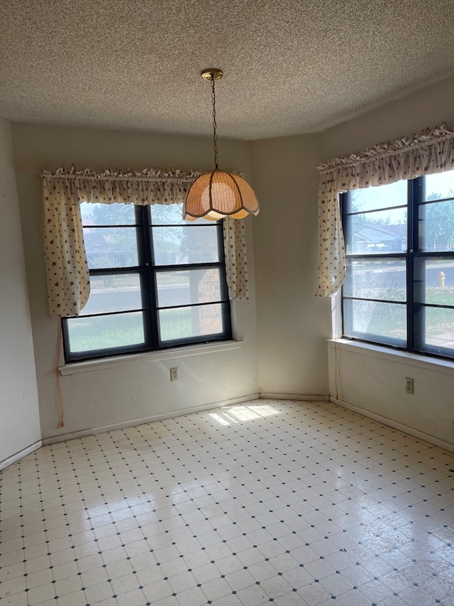 4400 Palmer Dr, Midland, TX 79705 - unfurnished dining area with a textured ceiling, baseboards, and light floors