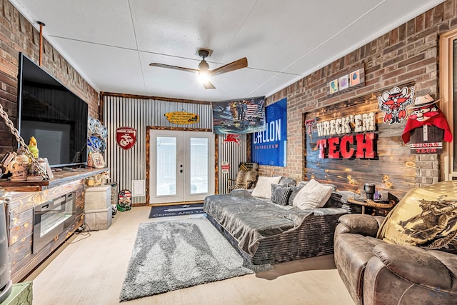 living area with ceiling fan, brick wall, and french doors