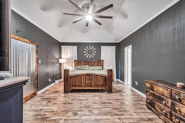 bedroom featuring lofted ceiling, ceiling fan, baseboards, and wood finished floors