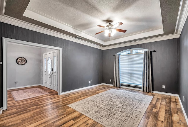 entrance foyer with wood finished floors, plenty of natural light, and a raised ceiling