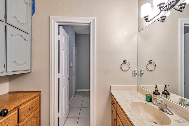 bathroom with tile patterned flooring, a notable chandelier, and vanity