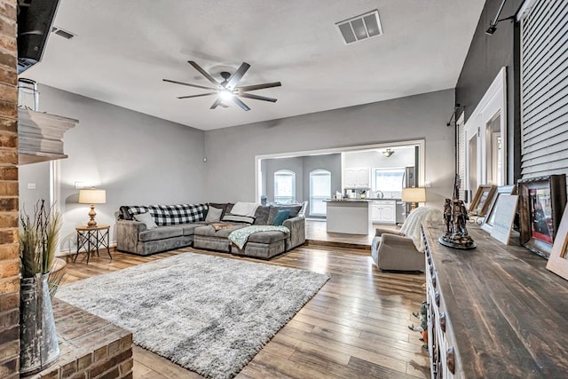 living area featuring wood finished floors, visible vents, and a ceiling fan