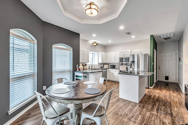 kitchen featuring visible vents, appliances with stainless steel finishes, white cabinets, and a center island