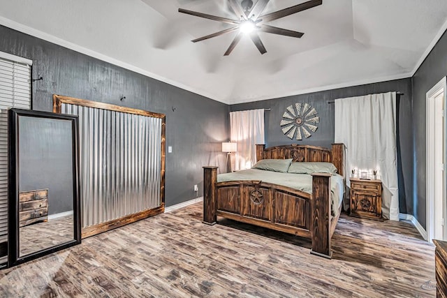 bedroom with ceiling fan, wood finished floors, baseboards, vaulted ceiling, and ornamental molding