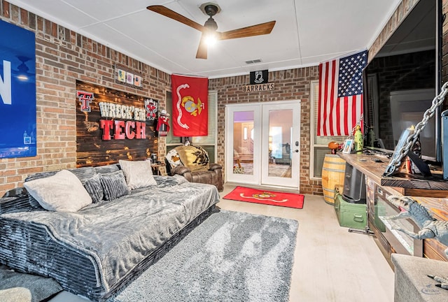 living room featuring french doors, visible vents, ceiling fan, and brick wall