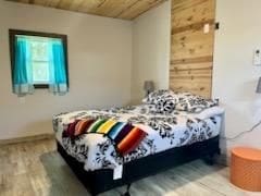 bedroom featuring hardwood / wood-style floors and wood ceiling