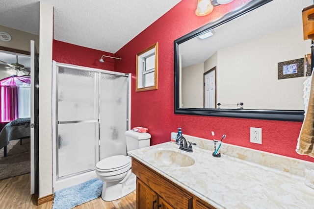 491 County Rd 202, Seminole, TX 79360 - full bathroom with wood finished floors, a stall shower, a textured wall, toilet, and vanity