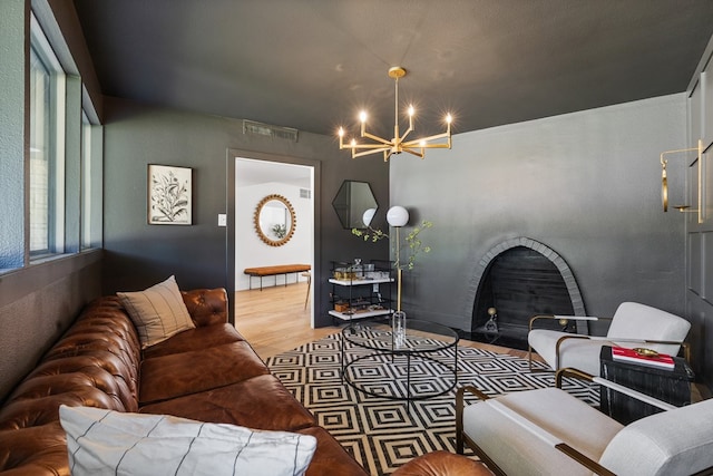 1611 W Tennessee Ave, Midland, TX 79701 - living room featuring a chandelier, a fireplace with flush hearth, and wood finished floors