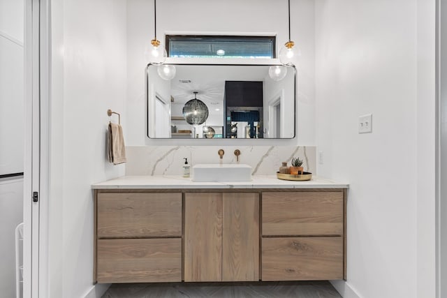 1611 W Tennessee Ave, Midland, TX 79701 - bathroom with vanity, decorative backsplash, and baseboards