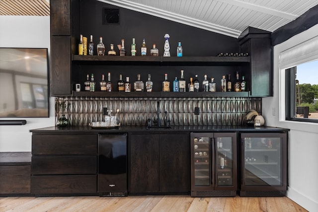 1611 W Tennessee Ave, Midland, TX 79701 - indoor bar with beverage cooler, light wood-style flooring, and baseboards