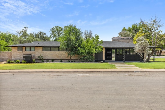 1611 W Tennessee Ave, Midland, TX 79701 - view of front of property with stone siding, a front lawn, and a shingled roof