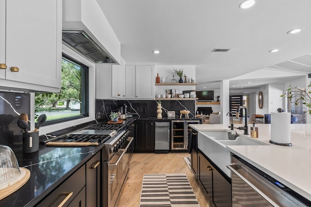 1611 W Tennessee Ave, Midland, TX 79701 - kitchen featuring stainless steel appliances, custom range hood, recessed lighting, light wood-type flooring, and decorative backsplash
