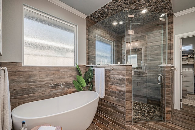 full bathroom featuring a stall shower, a freestanding tub, crown molding, and wood tiled floor