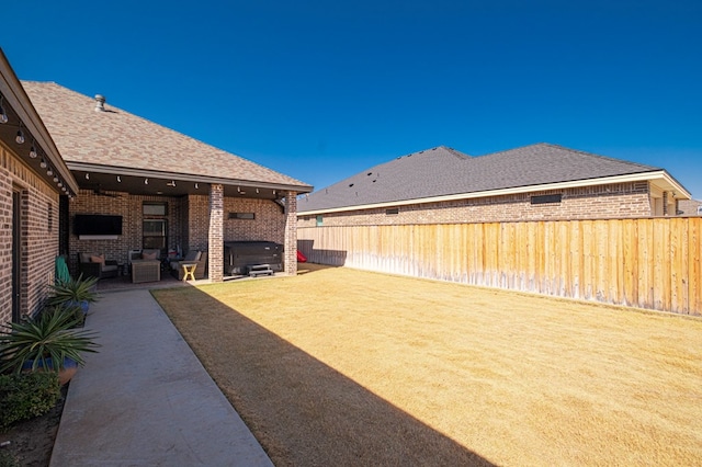 view of yard with a patio area, a fenced backyard, and a fireplace