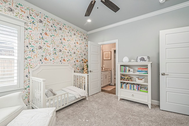 bedroom featuring a nursery area, multiple windows, crown molding, and wallpapered walls