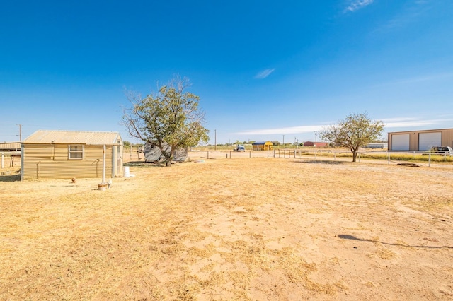 view of yard featuring a rural view and an outbuilding